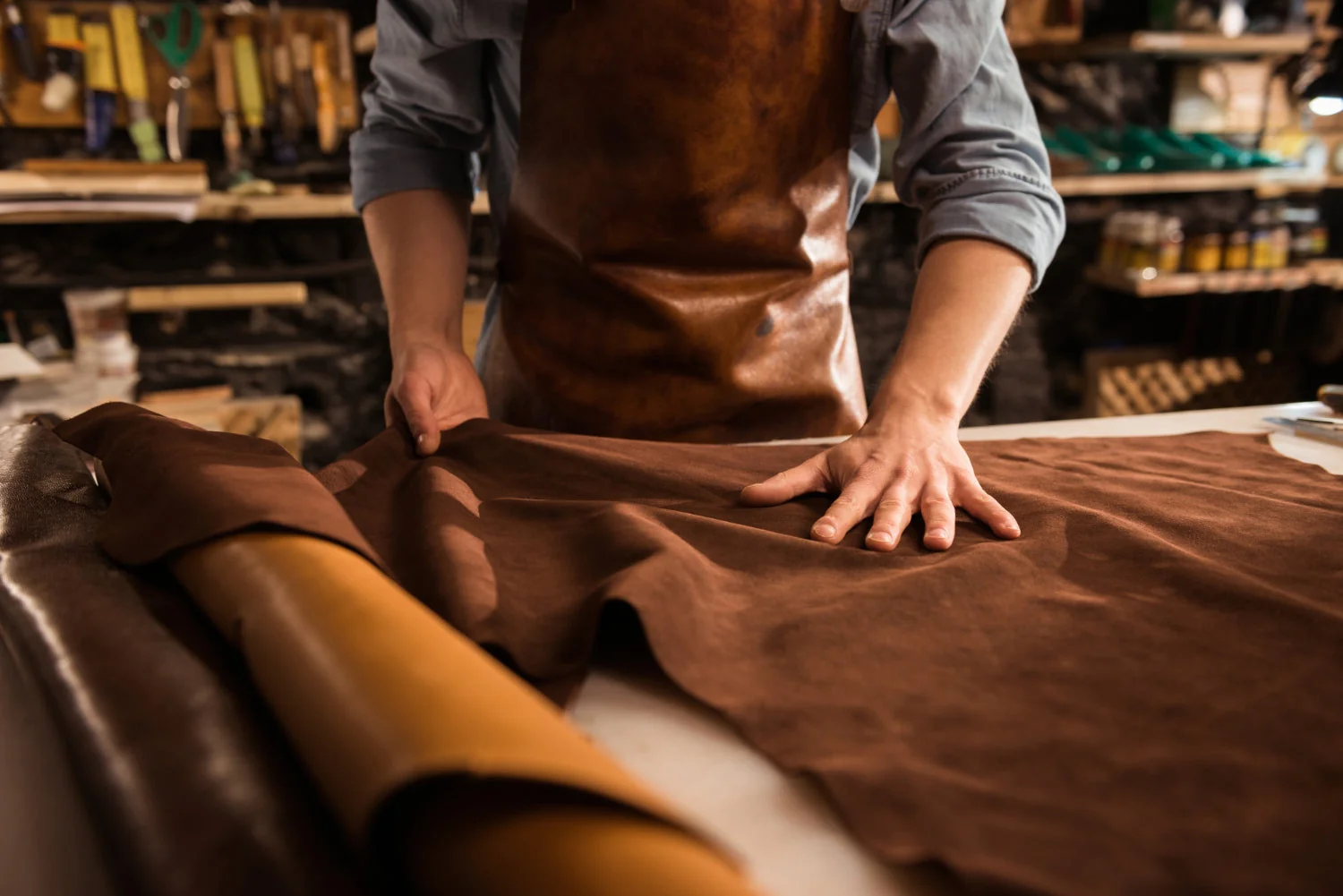 Close-up of a skilled leather craftsman working full grain buffalo leather at Cosmic Bag Industries in Kanpur, India